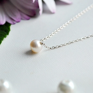 Baroque freshwater pearl pendant with silver stainless steel chain on elegant background