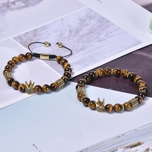 Detail view of tiger eye stone bead bracelets with gold crown and adjustable cords