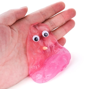 Pink transparent liquid glass slime toy with cute plastic eyes held in an adult's palm