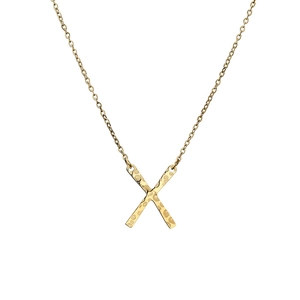 Détail macro du collier avec pendentif X plaqué or et fine chaîne O sur fond blanc