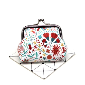 Close-up of floral coin purse with vintage metal clasp on minimalist white background