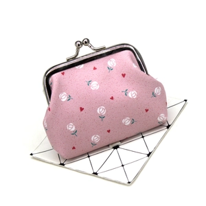 Detailed view of pink floral fabric coin purse with rose pattern and silver metal clasp