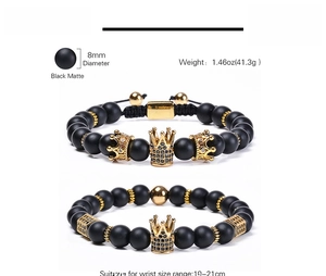 Macro detail of 8mm black matte stone beads and golden crown charm with zircon inlay