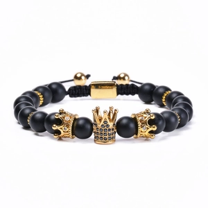 Black matte stone bead bracelet with a gold crown charm and adjustable drawstring cord