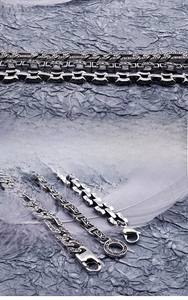 Macro detail of men's vintage tribal engraved stainless steel bracelets with lobster clasp