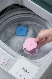 Floating flower-shaped washing machine lint filter bag collecting debris in water