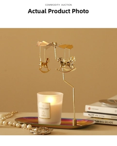Detail view of a golden spinning carousel candle holder with a colorful metal tray and candle