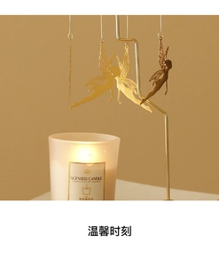 Detailed view of rotating golden fairy candle holder charms with delicate metal silhouette