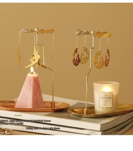 Detail of golden rotary candle holders with fairy and moon cat charms spinning by heat