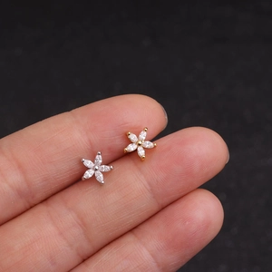 Minimalist gold and silver flower stud earrings with micro-set zircons on hand