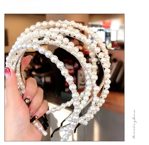 Detailed view of handmade pearl headbands with various bead sizes and gold accents