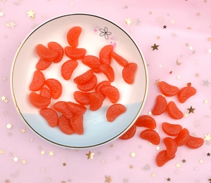 Detailed view of realistic orange segment miniatures with fruit texture in a white bowl