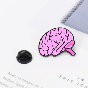 Detail of pink anatomical brain enamel pin with black rubber clutch on white surface