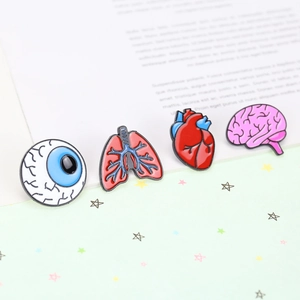 Detailed view of colorful anatomical enamel pins featuring heart, brain, and lung