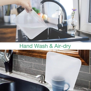 Reusable PEVA food storage bag being hand washed and air-dried in a kitchen setting