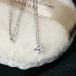 Elegant silver four-leaf clover pendant necklace with sparkling zircons on white fur