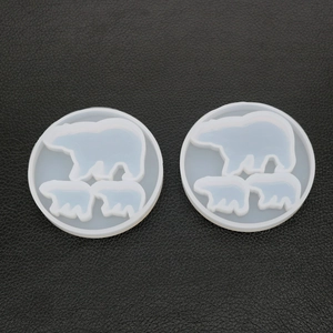 Detailed view of two circular silicone molds for resin casting featuring polar bear patterns