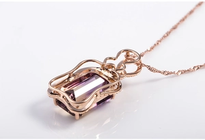 Macro shot of rectangular purple gemstone pendant with rose gold hollow wave setting