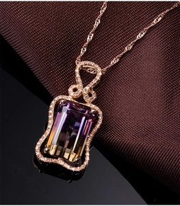 Detail of rose gold necklace featuring a rectangular bicolor gemstone pendant with diamonds
