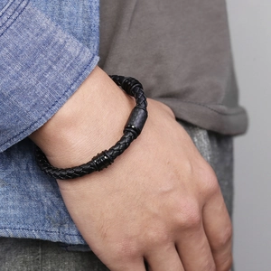 Men's black braided leather bracelet with carbon fiber beads on a model's wrist