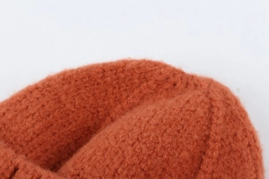 Macro detail of caramel orange knit beanie showing thick wool texture and fluffy fibers