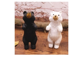 Gros plan de figurines d'ours en bois sculpté noir et blanc sur une table en bois naturel