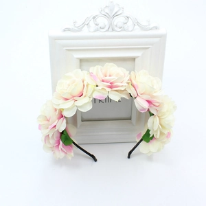 Detail of handmade ivory silk rose headband with pink gradient petals and green leaves