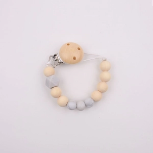 Detailed view of handmade silicone and wood baby pacifier clip with grey beads