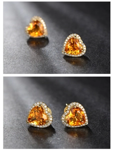 Detailed close-up of heart-shaped citrine earrings with gold plating and halo stones
