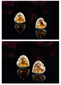 Detail of yellow heart gemstone stud earrings with a halo of small diamonds in gold