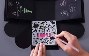 Close-up of DIY explosion box showing lace drawing stencils and creative hand-painted details