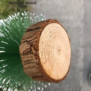 Close-up of a natural wood base for a mini Christmas tree with lifelike pine needles