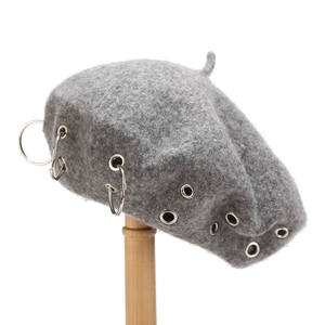 Grey wool beret hat featuring punk style metal eyelets and decorative silver rings