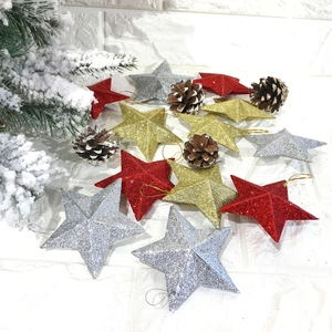 Glittering star ornaments in red, gold, and silver with pine cones for Christmas decor