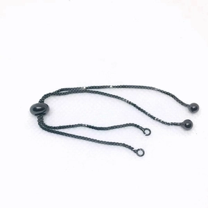Macro view of adjustable gunmetal box chain with sliding toggle and sphere ends