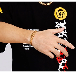 Close-up of a men's gold chunky Cuban chain bracelet with a dragon head clasp detail