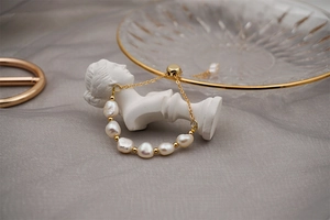 Detailed view of freshwater baroque pearl bracelet with adjustable gold titanium chain