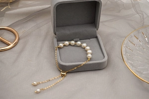 Detail of adjustable 14k gold plated chain bracelet with seven round freshwater pearls