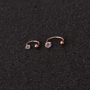 Macro shot of two rose gold C-shaped nose studs with sparkling cubic zirconia stones