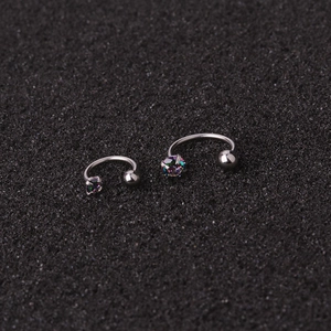 Macro shot of U-shaped silver ear studs with rainbow cubic zirconia and metal ball ends