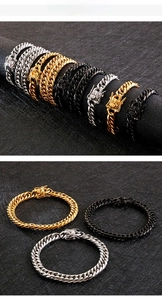 Detail of Cuban link chains in gold, silver and black with embossed animal pattern clasp
