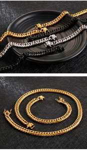 Detailed view of 18K gold, silver and black chunky Cuban chains with dragon-head clasps