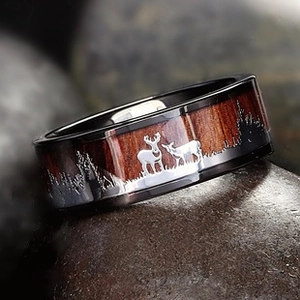 Macro detail of men's black ring with wood inlay and elk forest silhouette engraving