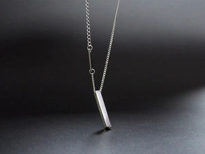 Macro detail of silver rectangular bar pendant with Live For Yourself engraving