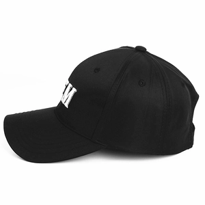 Macro detail of white M letter embroidery on black cotton twill baseball cap