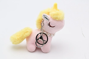 Detail of pink plush unicorn keychain with pearl necklace and silver metal clasp