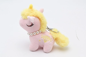 Close-up of pink plush unicorn keychain with yellow mane and pearl necklace detail