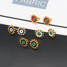 Macro detail of four pairs of enamel evil eye stud earrings with gold metal base