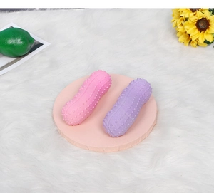 Close-up of peanut-shaped textured rubber dog toys in pink and purple colors