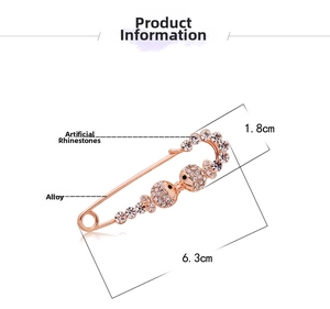 Detail of rose gold fish safety pin brooch with sparkling crystal rhinestones inlay